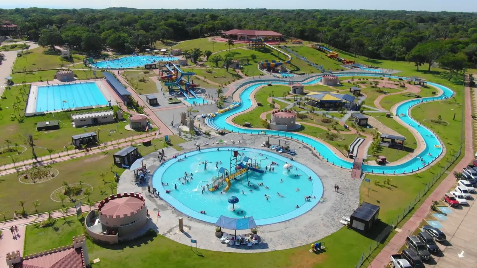 Vista aérea de Kalomai Park con el río lento, las piscinas y el parqueo llenos de gente